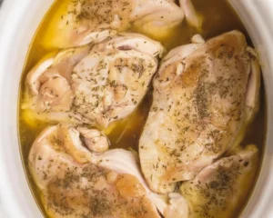 A deliciously juicy crockpot chicken breast served with fresh herbs and spices.