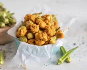 Crispy Southern fried okra with a golden cornmeal crust on a plate.
