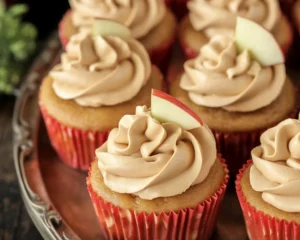 Delicious Apple Cider Cupcakes topped with Spiced Buttercream Frosting and apple chunks.