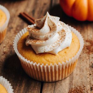 Pumpkin cheesecake cupcake topped with whipped cream