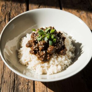 Korean ground beef bowl with rice, sesame seeds, and green onions.