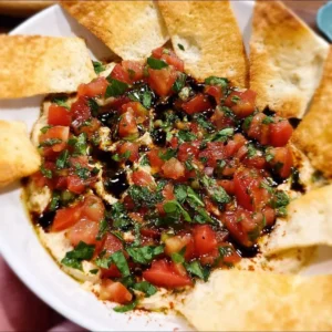 Delicious bruschetta dip served in a bowl with toasted bread slices