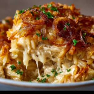 French onion chicken orzo casserole topped with melted cheese and herbs