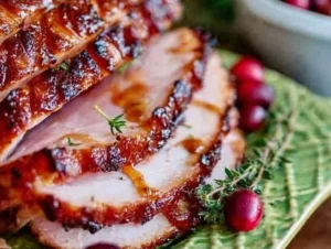 Oven-roasted ham glazed with a sweet and savory glaze for holiday meals.