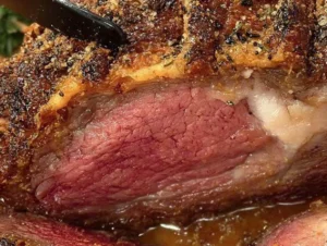 Perfect prime rib roast with herb-garlic crust, beautifully presented on a platter.