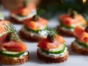 Elegant smoked salmon canapés topped with cream cheese and herbs on a platter.