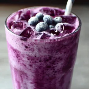 Cottage cheese blueberry smoothie in a glass with fresh blueberries and mint.