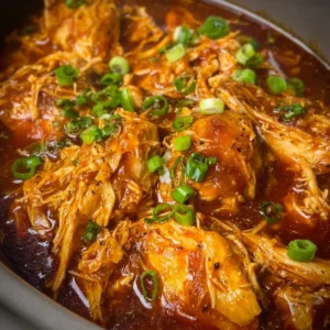 Crockpot shredded bourbon chicken thighs ready to be served.