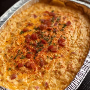 Creamy hot pimento cheese dip served in a bowl with crackers and vegetables