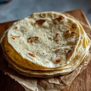 Homemade sourdough tortilla stacked on a wooden table