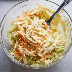 Bowl of homemade coleslaw dressing with ingredients ready for mixing