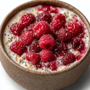 Bowl of raspberry overnight oats topped with fresh raspberries and almonds