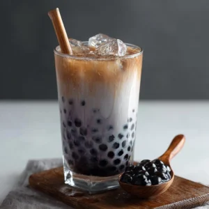 Creamy black sesame milk tea with boba served in a glass