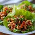 Plate of Asian Turkey Lettuce Wraps garnished with sesame seeds and green onions.