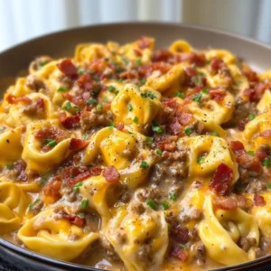 Delicious plate of Bacon Cheeseburger Tortellini topped with cheese and bacon.