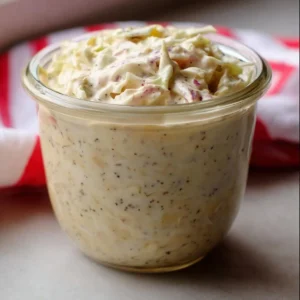 Homemade coleslaw dressing in a bowl with fresh ingredients