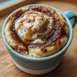 Cottage cheese cinnamon roll mug cake topped with icing and cinnamon.