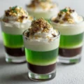 Colorful Leprechaun Shots in layered glassware, perfect for St. Patrick's Day celebration.