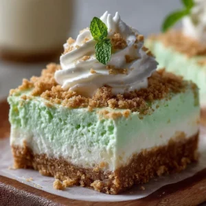 No-Bake Shamrock Shake Cheesecake Bars topped with green whipped cream and sprinkles