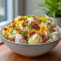 Delicious loaded potato salad with bacon, cheese, and green onions in a bowl