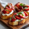Plate of Strawberry Ricotta Bruschetta topped with fresh strawberries and mint