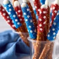 Patriotic chocolate dipped pretzel rods decorated with red, white, and blue sprinkles