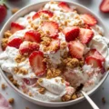 Delicious strawberry cheesecake salad served in a bowl with fresh strawberries.